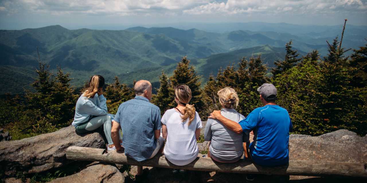 Perhe istuu näköalapaikalla