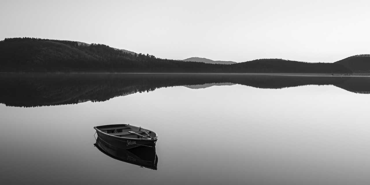 Vene peilityynillä järvellä