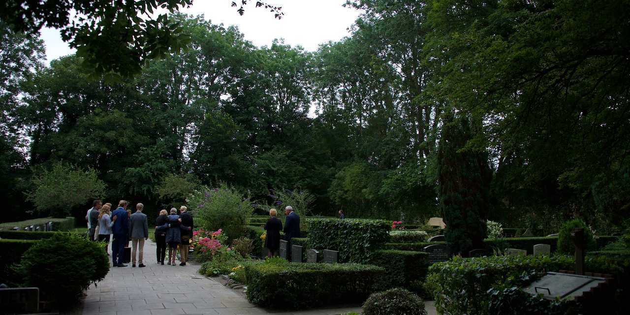 Ihmisiä hautausmaalla.