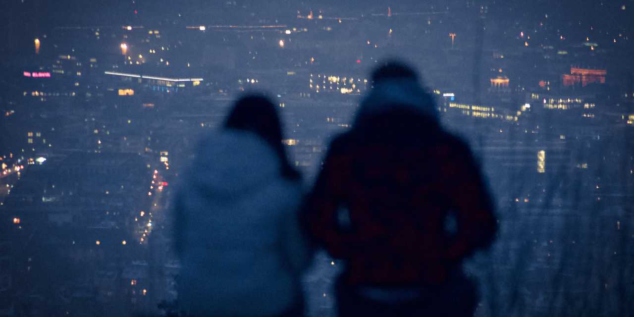 Pariskunta katsoo pimenevää kaupunkia