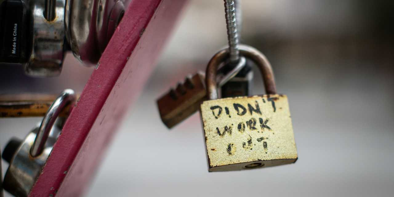 Ett hängande hänglås med texten "didn't work out", flera hänglås i bakgrunden