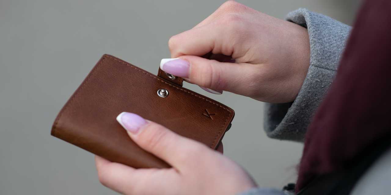 Nainen avaa lompakon
