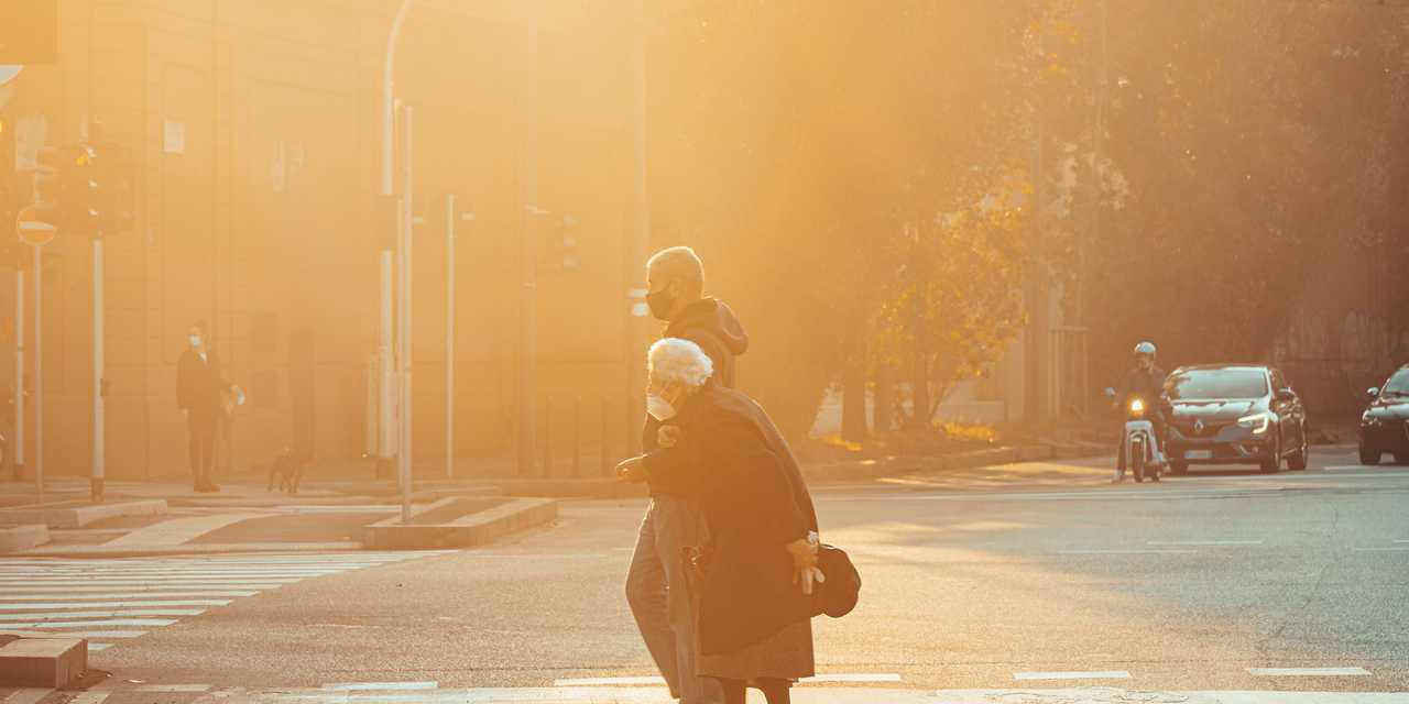 Mies ja vanhus ylittämässä katua.