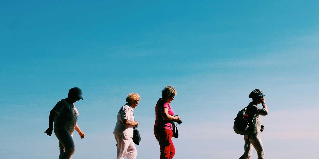 Fire mennesker der går i solen