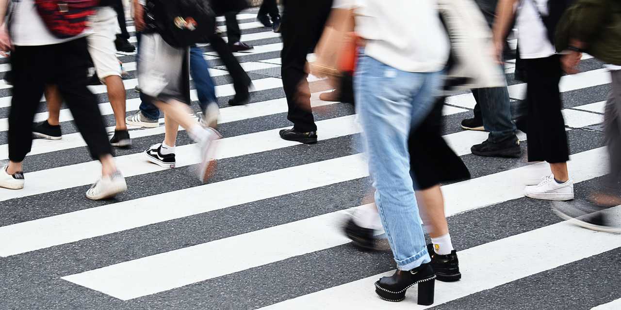 Mennesker krydser vejen ved et fodgængerovergang.