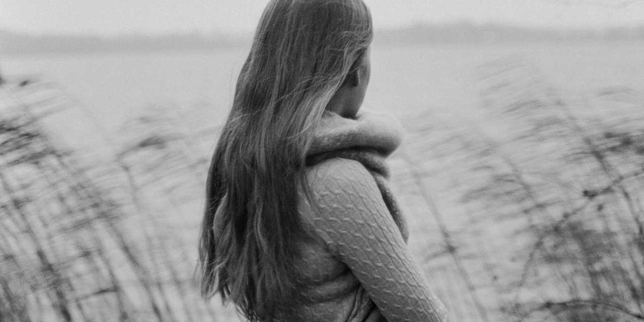 Henkilö seisoo rannalla.