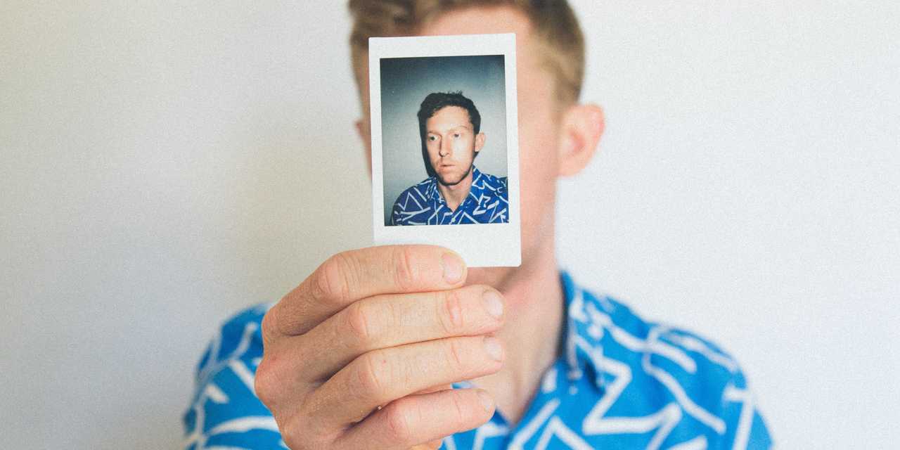 Man som håller upp en bild på sig själv