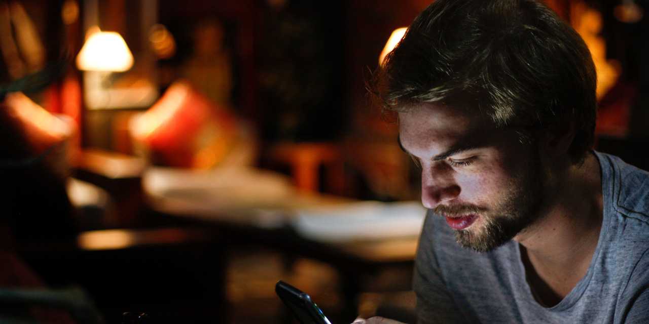 Mies puhelimella kirjastossa