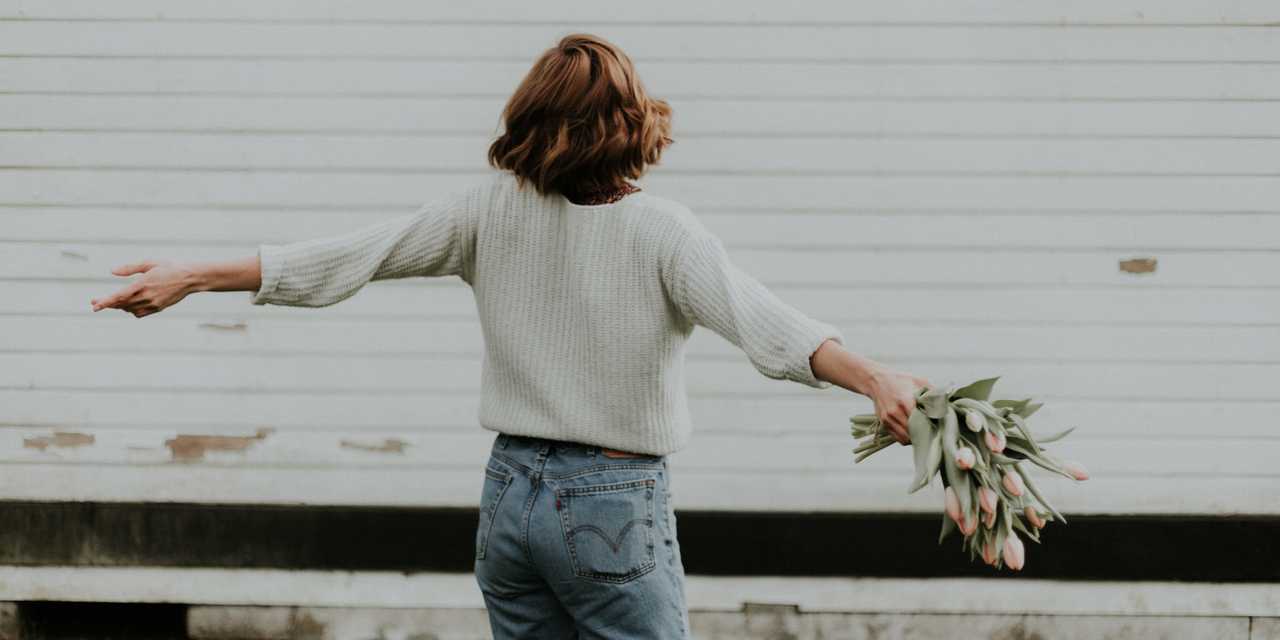 Nainen tanssii tulppaanikimpun kanssa