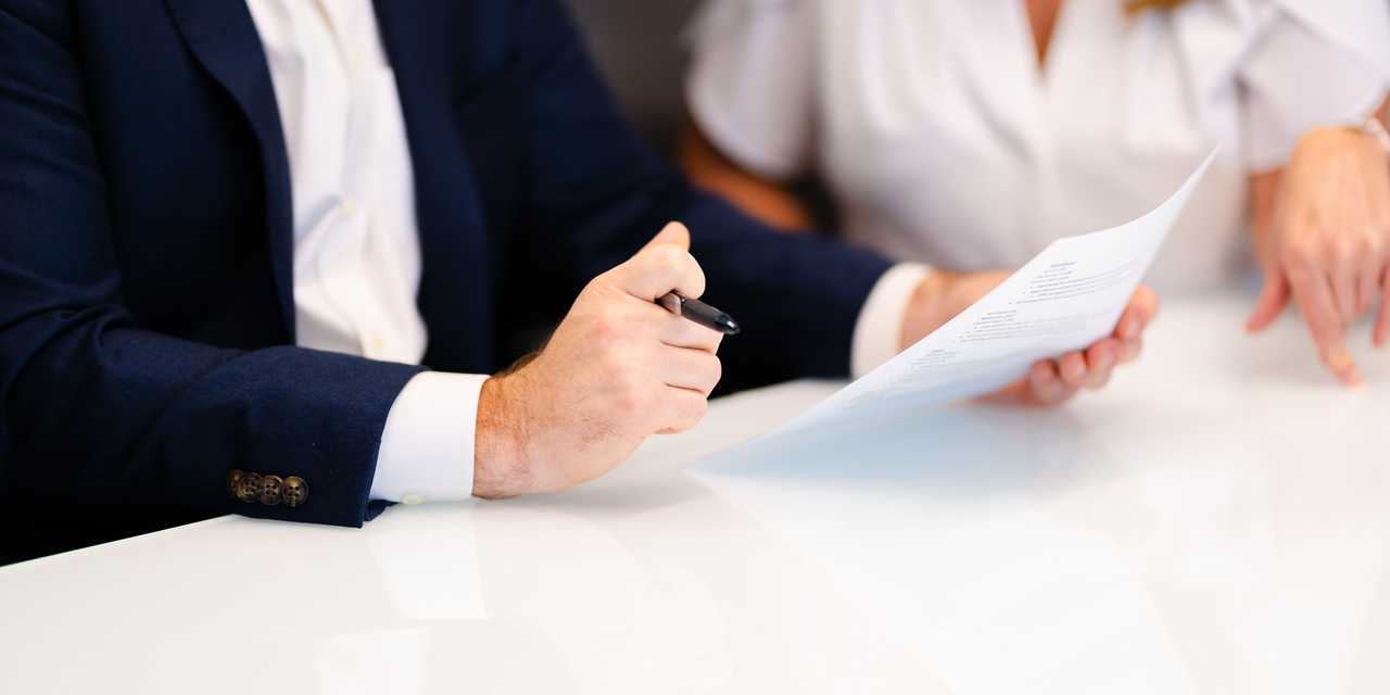 Mies ja nainen allekirjoittavat asiakirjaa
