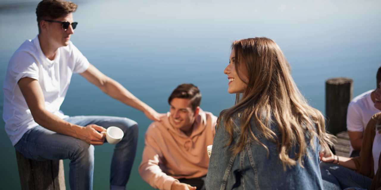 Nuoret juovat kahvia laiturilla