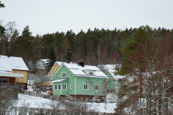 omakotitaloja lumisessa maisemassa. 