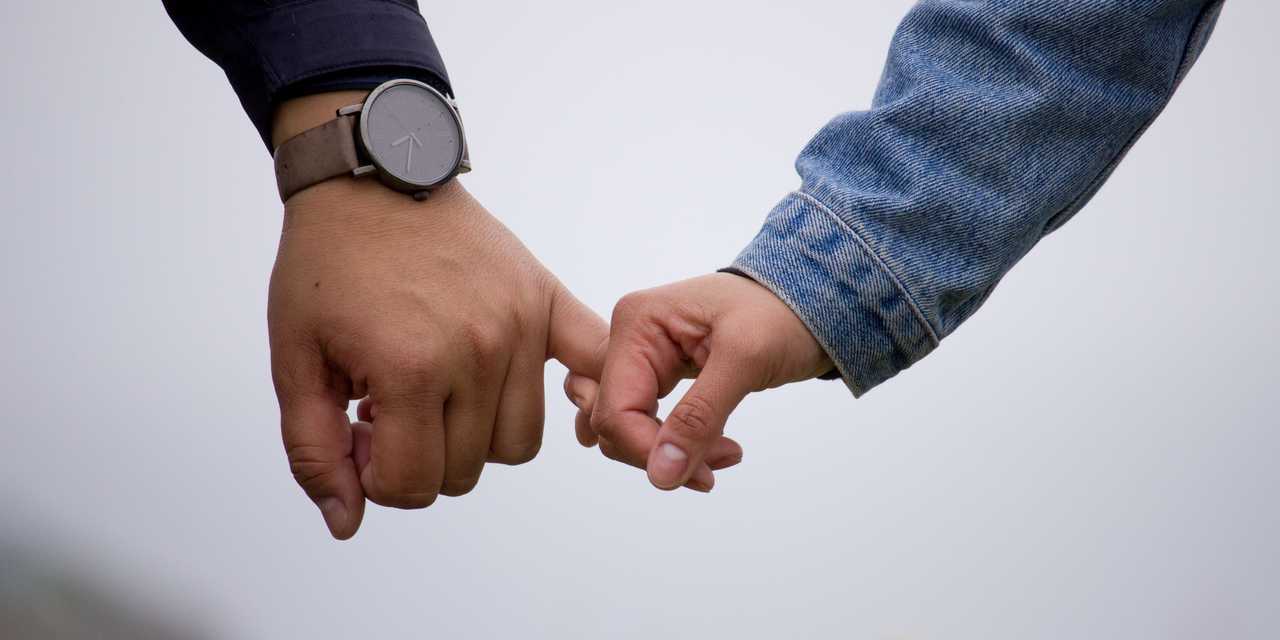 Lähikuva käsistä, jotka pitävät toisistaan kiinni