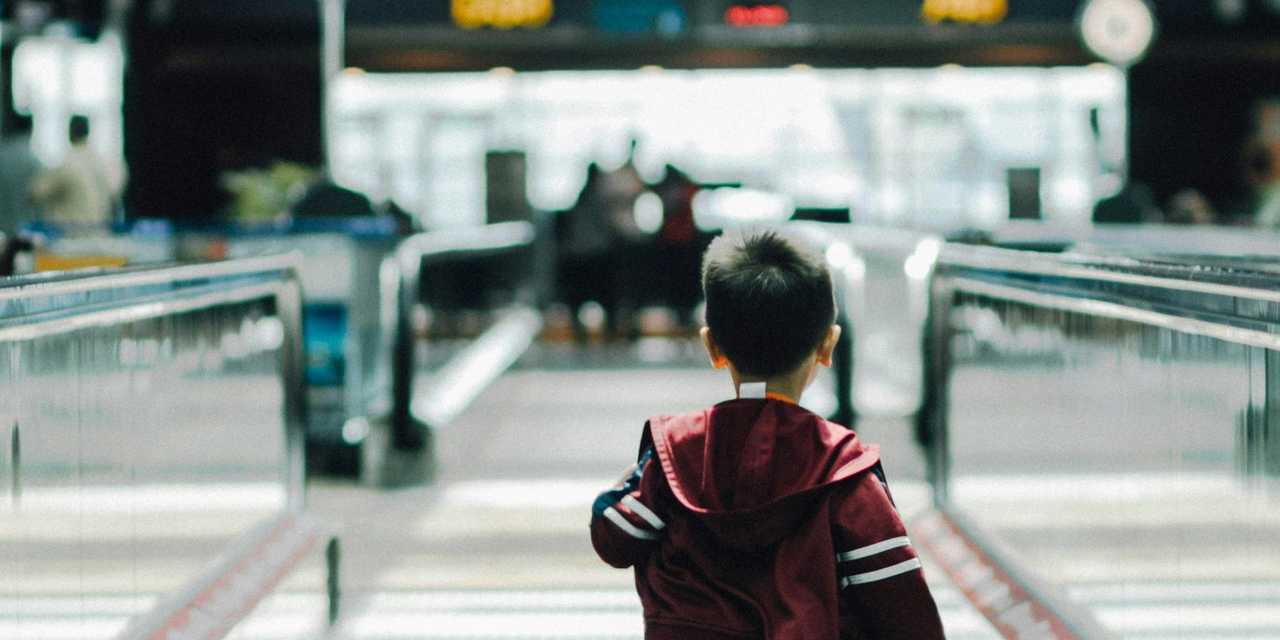 boy running at escalator belt at airport 
