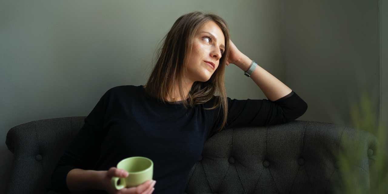 Nainen istuu sohvalla